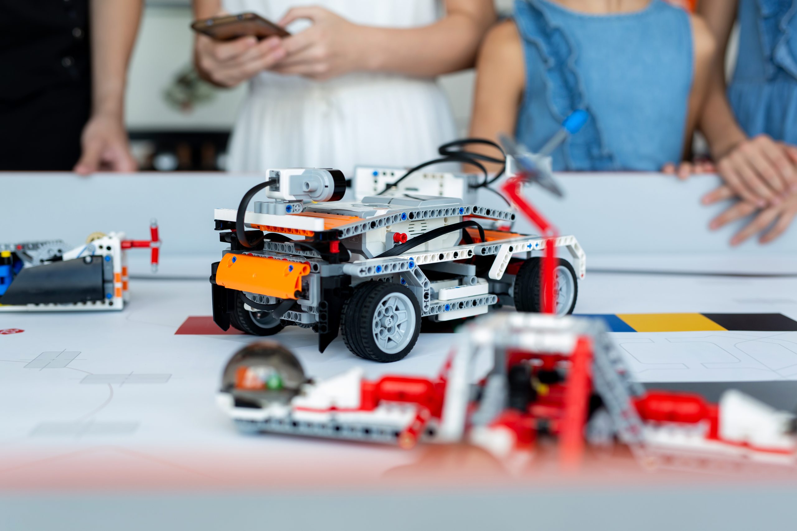 Close-up children control cars robots assembled from a construct